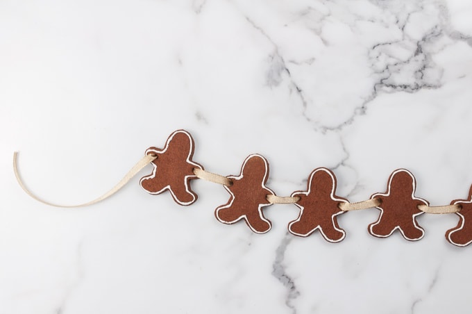 Gingerbread Men Cookie Garland - create this cute craft by making a cinnamon applesauce dough. These are adorable and make your house smell like Christmas cookies!