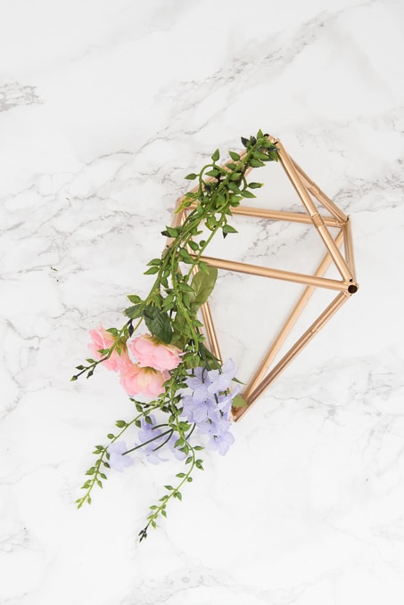 Pretty idea and unique take on a spring wreath! This geometric floral door hanger is gorgeous and a budget friendly way to create a unique spring decoration.