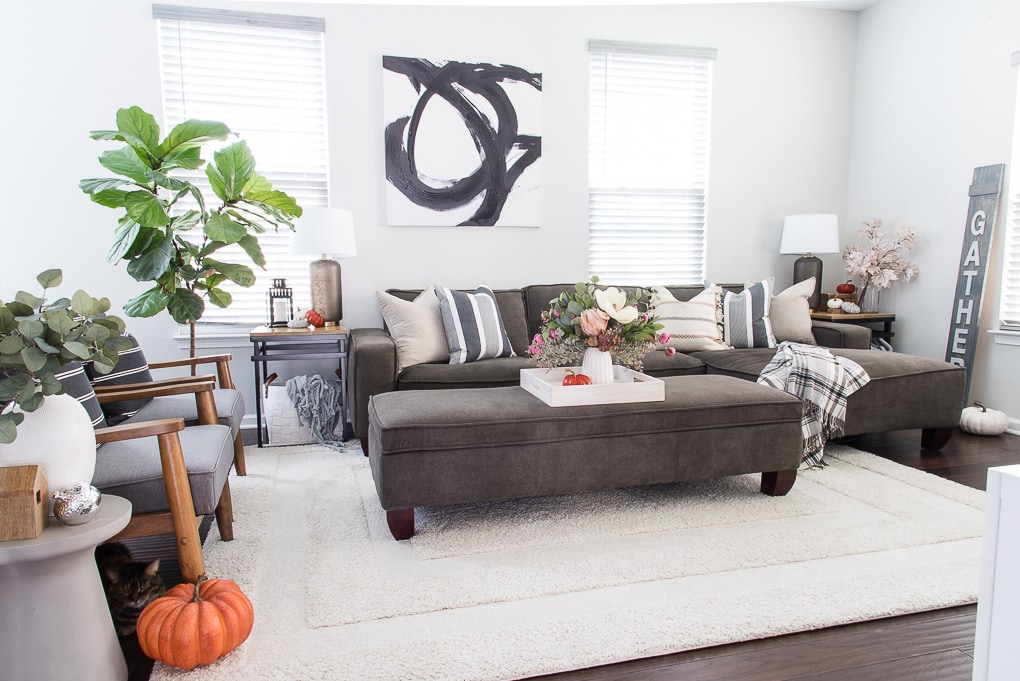 fall living room with blue and neutral throw pillows and a faux floral arrangement