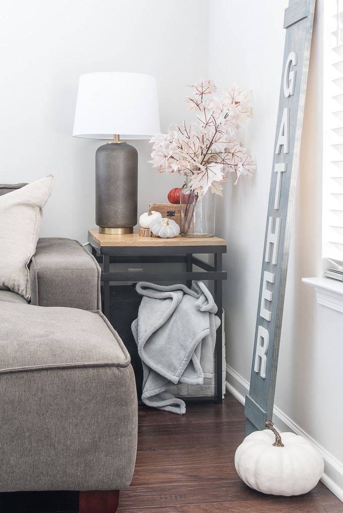 end table in living room with fall decorations and pink leaves