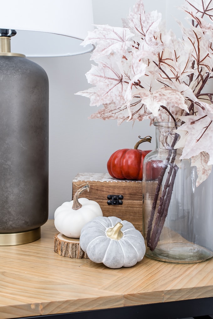 white gray and orange pumpkins on an end table for fall