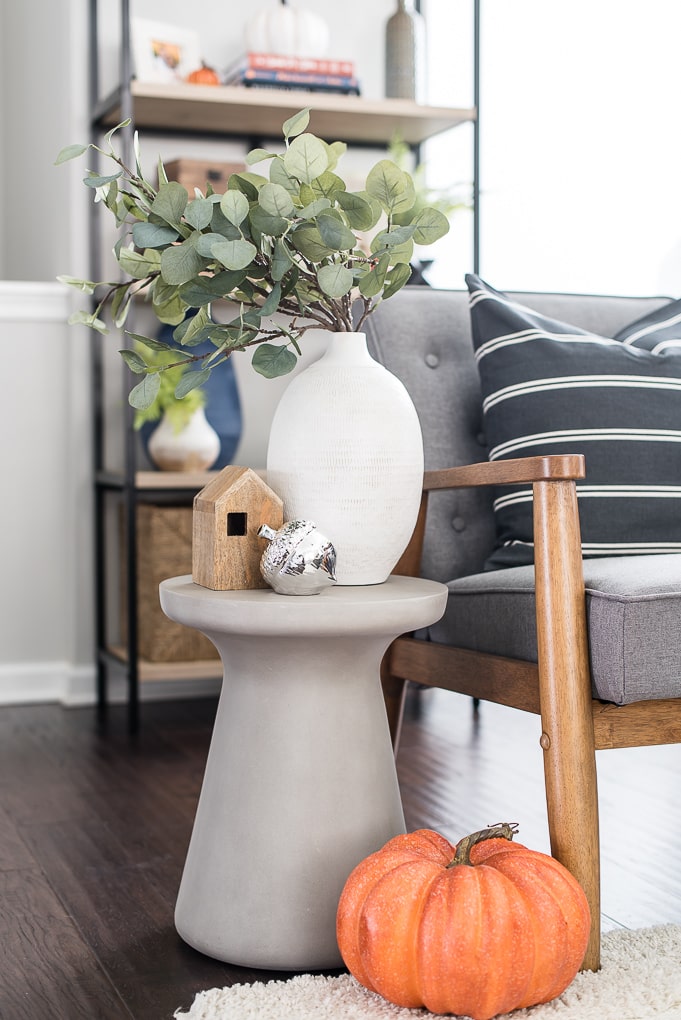 side table vignette white vase eucalyptus and orange pumpkin