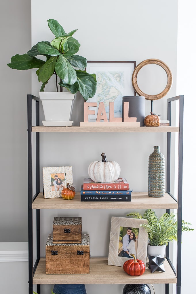 natural wood bookshelf with fall decorations on the shelves