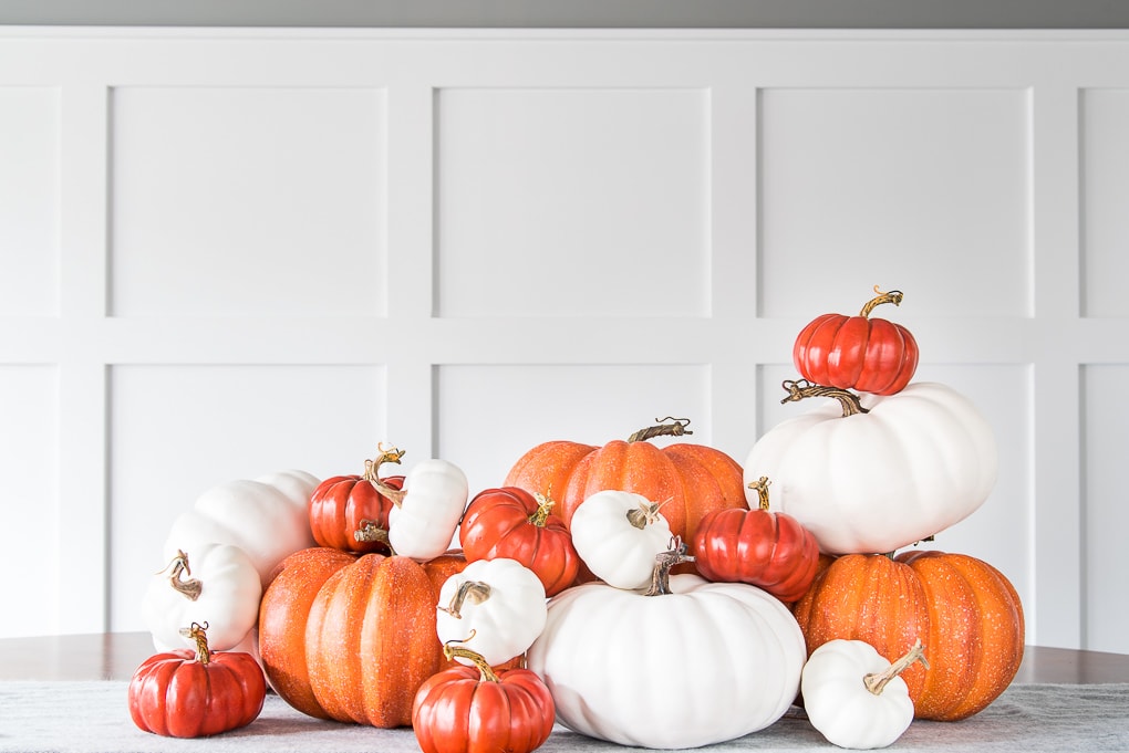 pile of orange and white pumpkins on a table