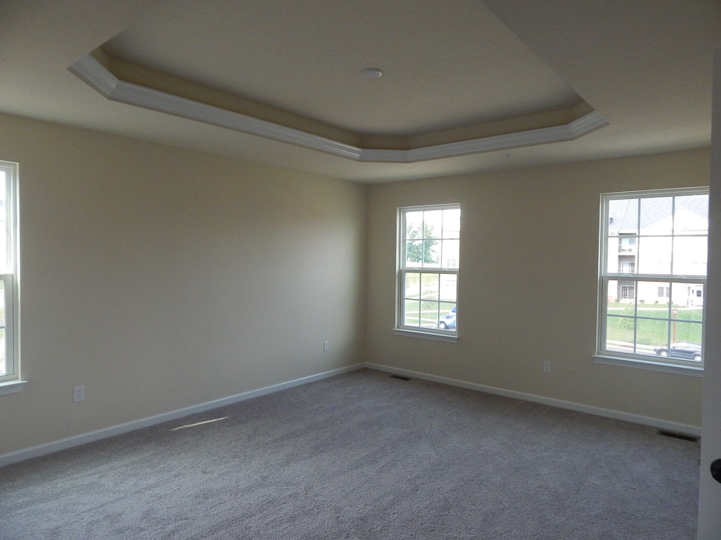 yellow empty master bedroom builder grade room