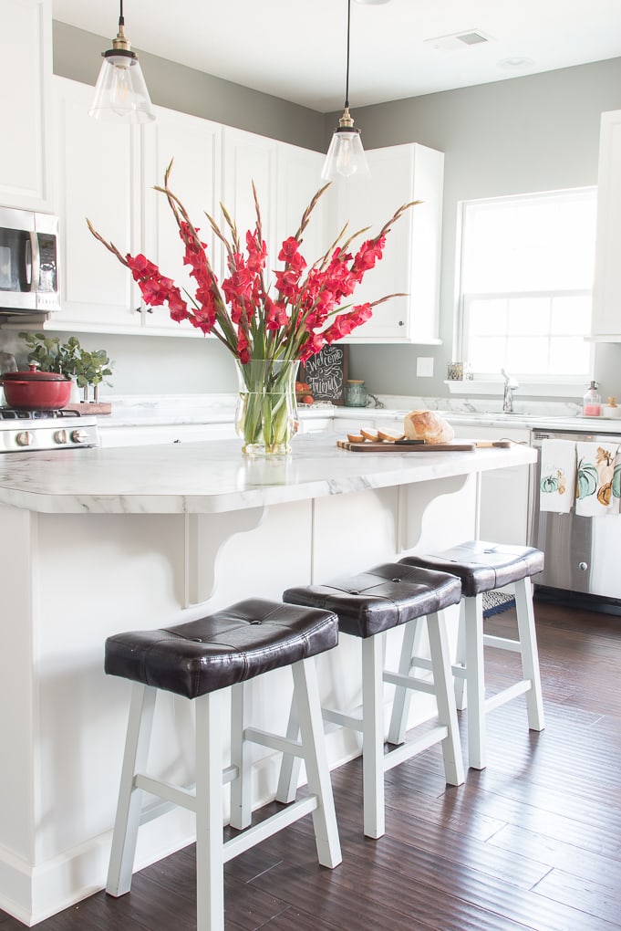 bright white kitchen with pink flowers on the island