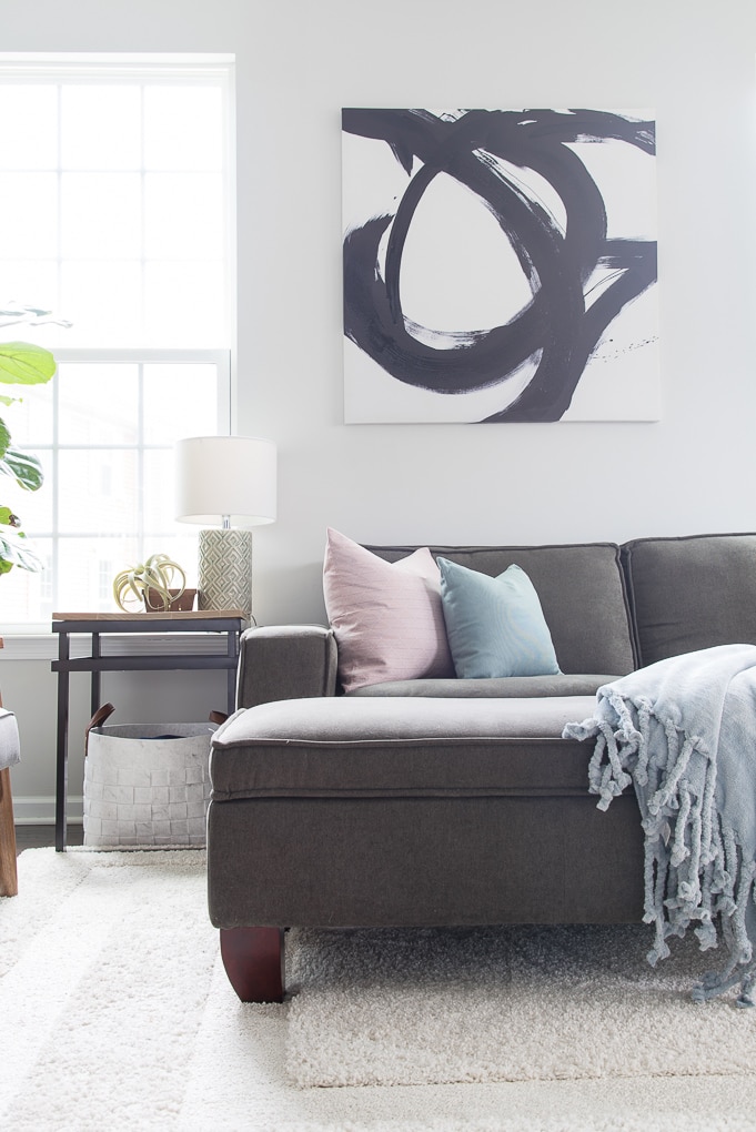 bright living room with gray couch throw pillows and blanket