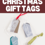 Four DIY layered gift tags are displayed on a white surface, each featuring festive phrases: "joy to the world," "let it snow," "merry and bright," and "peace on earth." Adorned with decorative ribbons in red, white, green, and beige, these layered gift tags add a charming touch to any Christmas present.