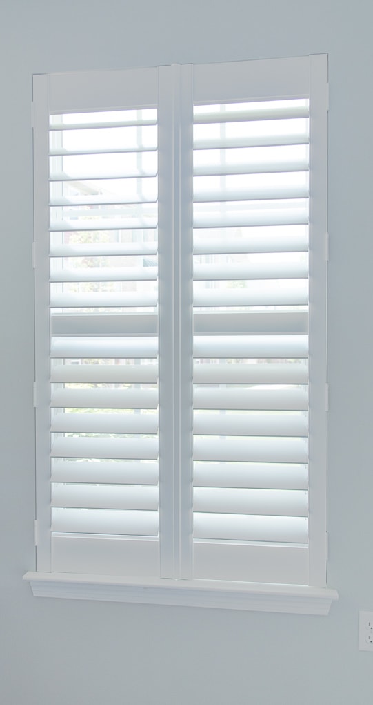 white plantation shutters closed on a window