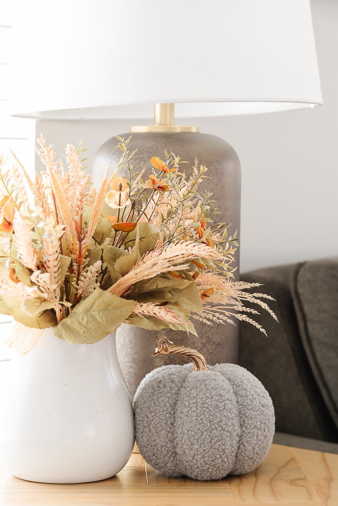 fall floral bunch in white vase with knitted gray pumpkin