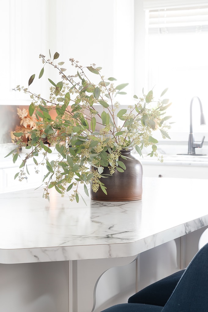 seeded eucalyptus in fall vase on white kitchen island