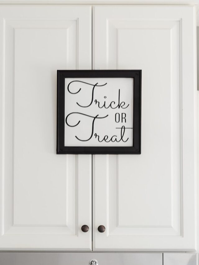 black and white trick or treat sign on white kitchen cabinet