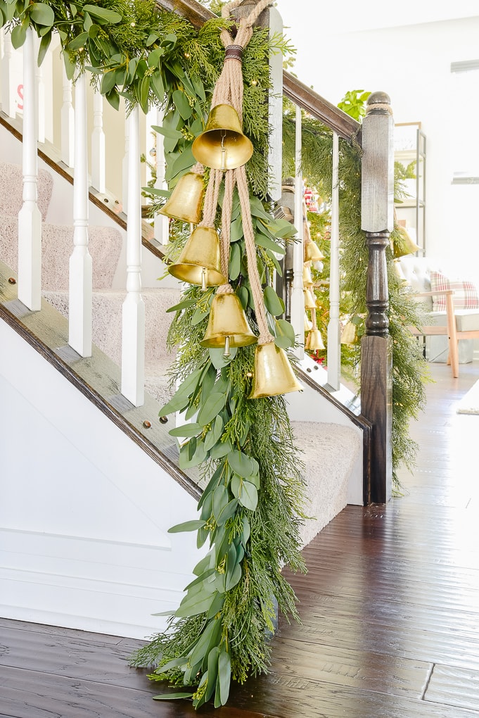 pine and eucalyptus Christmas garland at end of staircase with strand of golden hanging bells