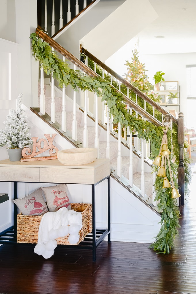 staircase with pine and eucalyptus Christmas garland and golden bells