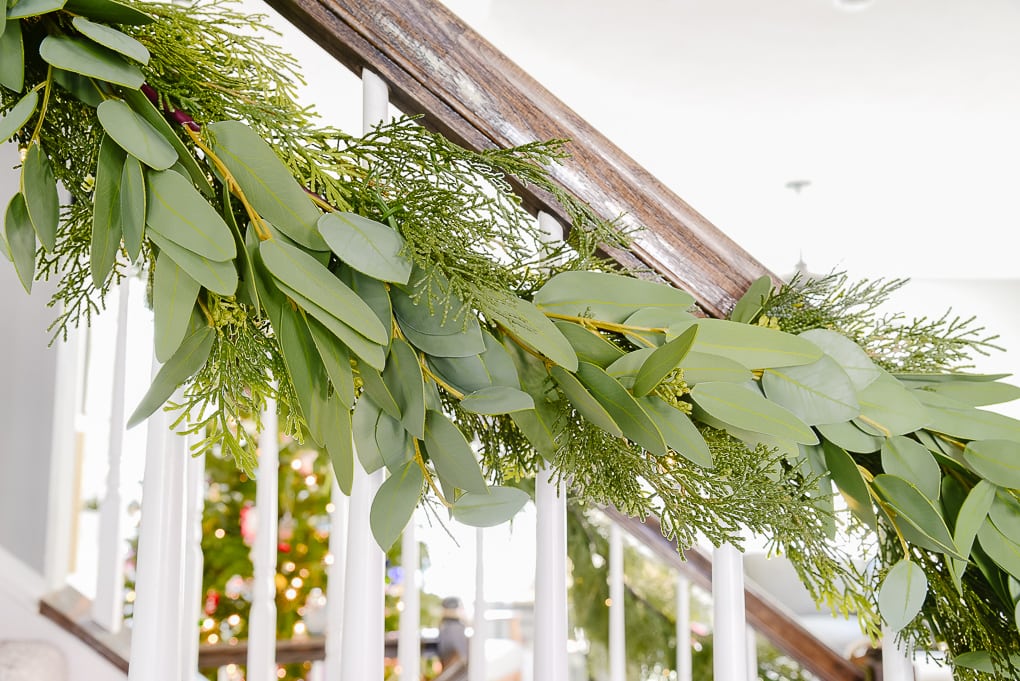 pine and eucalyptus Christmas garland attached to staircase railing