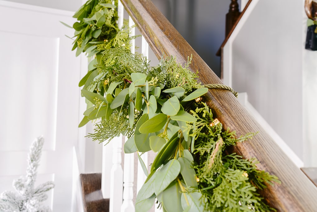 pine and eucalyptus garland attached to staircase railing