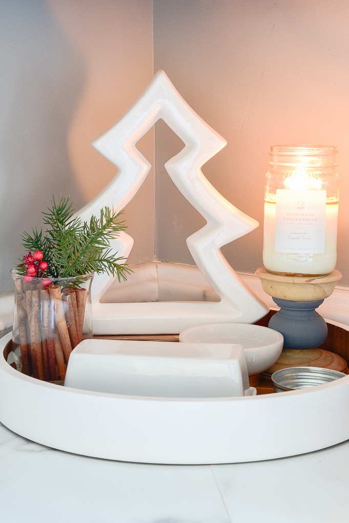 white tree figurine on tray in kitchen next to candle burning