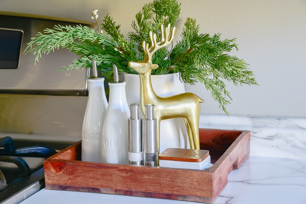 Christmas kitchen decor tray with greenery in a white vase and gold reindeer