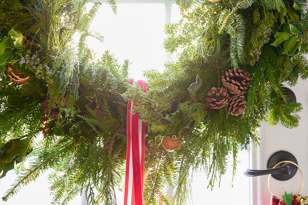 close up of handmade fresh Christmas greenery wreath on glass door