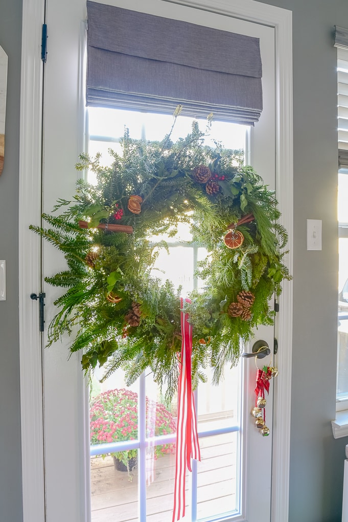 handmade fresh Christmas greenery wreath on glass door