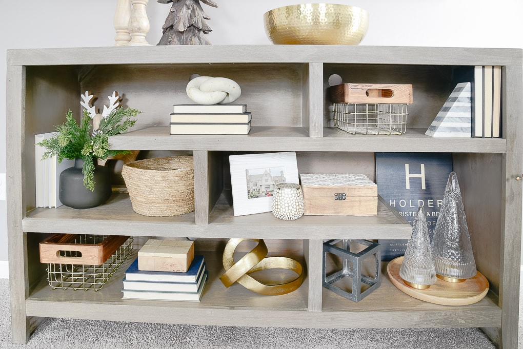 gray bookshelves decorated and styled for Christmas with gold and wooden accents