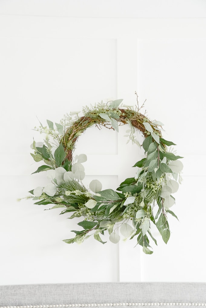 modern greenery and eucalyptus wreath against white board and batten wall