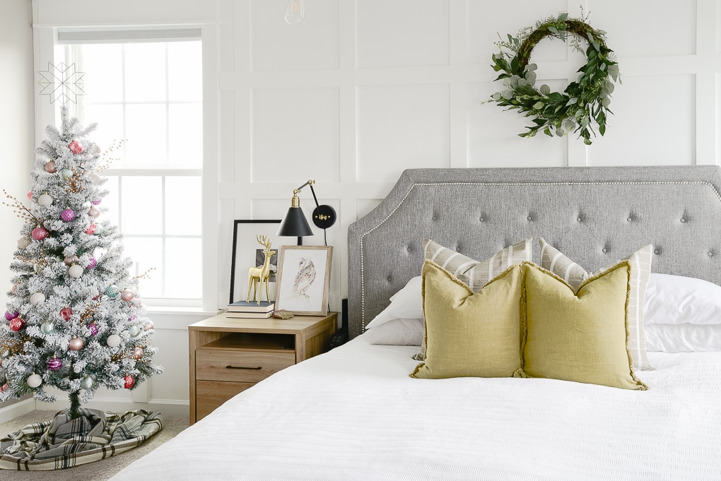 master bedroom bed and christmas tree decorated for the holidays