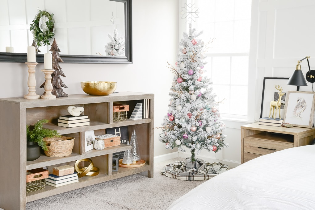 flocked decorated christmas tree in the corner of a master bedroom