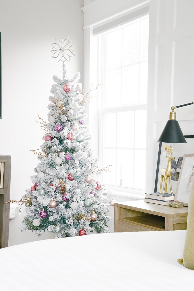 flocked christmas tree decorated with plaid tree skirt and colorful ornaments