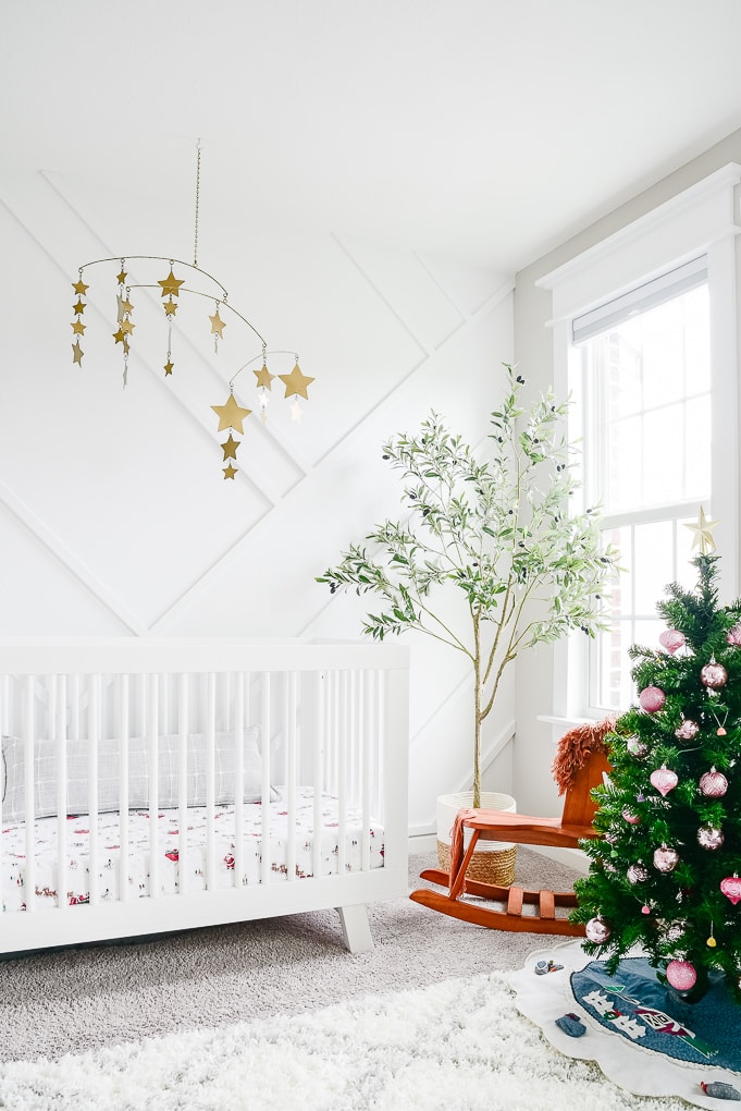 baby nursery white decorated with a kids christmas tree for the holidays