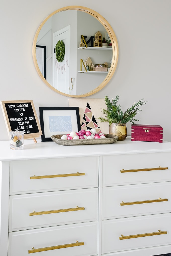 the top of a white dresser in a nursery decorated for Christmas