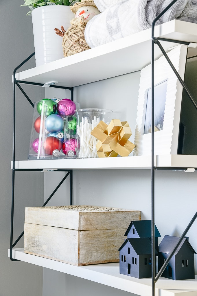 white wood shelf with black metal brackets in powder room decorated for Christmas