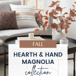 A cozy living room setup featuring a sofa with cushions, a round black coffee table adorned with a vase of autumnal foliage, and decor accents. Text overlay reads, "Hearth and Hand with Magnolia Target Fall Collection" with a website link at the bottom.