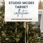 A Christmas tree adorned with various ornaments, including baubles, lights, and garlands, stands in a cozy, decorated room. Above and overlaying the image is text reading: "NEW! Studio McGee Target Christmas Collection" with a website link "CHRISTENEHOLDERHOME.COM" displayed below.