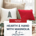 A cozy scene featuring a beige window seat adorned with pillows and blankets. One pillow is white with a green tree, the other is red with white patterns. A plaid blanket lies beneath. A sign promotes the Hearth & Hand with Magnolia Target Christmas Collection.