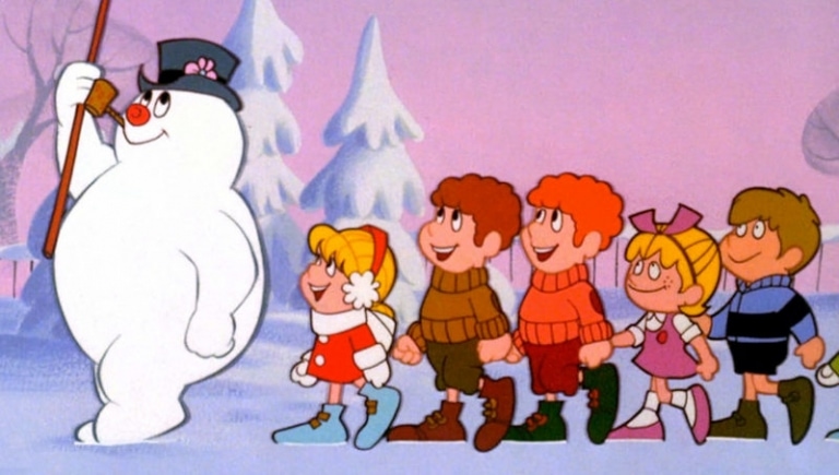 An animated image of a jolly snowman wearing a black hat and carrying a broom, leading a group of five children. The children, dressed in winter clothing, cheerfully follow him across a snowy landscape with frosted trees in the background — reminiscent of scenes from the best Christmas movies for 4 year olds.