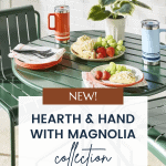 An outdoor table is set with plates of food, including fruit and pasta, and two insulated cups. The table has a green theme and is placed in front of a white brick wall with a green plant. Text over the image reads, "NEW! Hearth & Hand with Magnolia Target Summer Collection" and a website link.